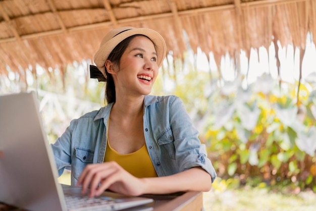 Free photo asian female freelance digital normad millennial gen y lifestyle relax casual working with laptop outdoor at balcony near the beachasian female working anywhere new lifestyle working while travel