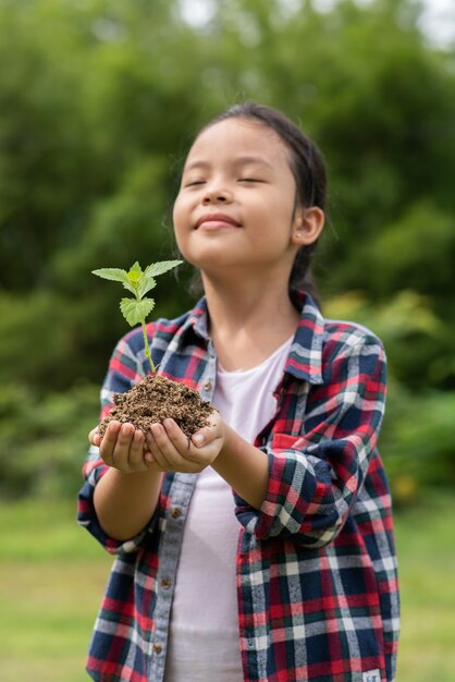 Free photo asian girl holding plant and soil