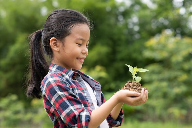 Free photo asian girl holding plant and soil