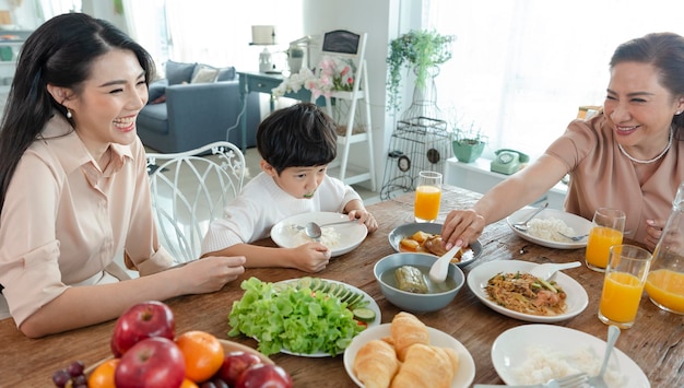 Free photo asian happy family spend time having lunch on table together relationship and activity in house