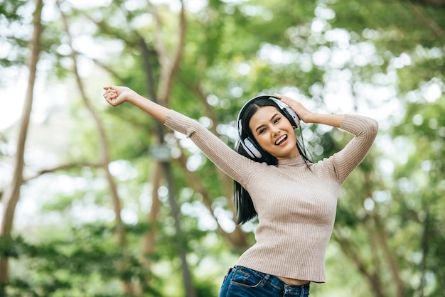 Бесплатное фото Азиатская женщина, слушать любимую музыку в наушниках. счастливое время и отдохнуть.