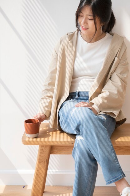 Free photo asian woman with a cup of coffee in her hand