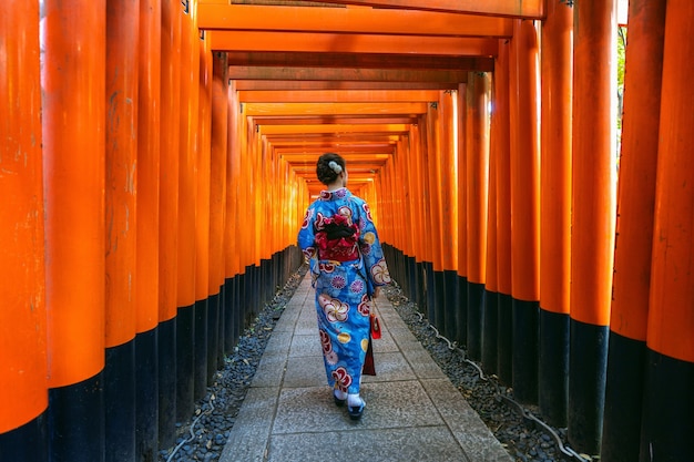 無料Photo 京都の伏見稲荷神社で伝統的な日本の着物を着たアジアの女性。