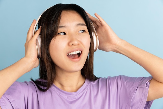 Asian young woman's portrait on blue studio background Concept of human emotions facial expression youth sales ad