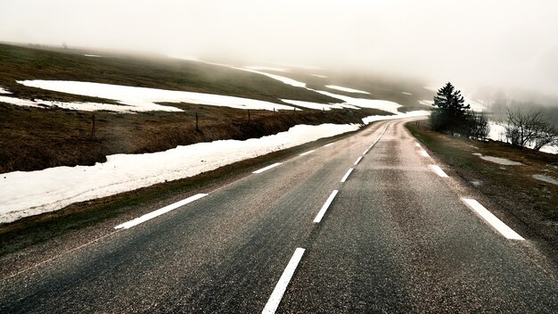 Asphalt road on a hill covered with snow during winter