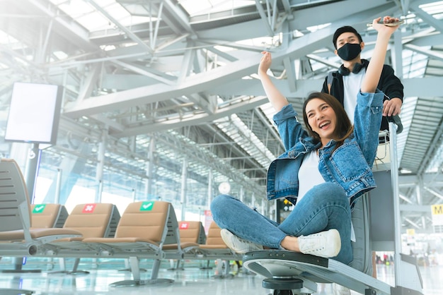 Free photo attractive young asian tourist couple excited together for the trip girlfriend sitting and cheering on baggage trolley or luggage trolley holiday vacation safety traveling abroad ideas concept