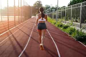 Free photo back view woman running on track