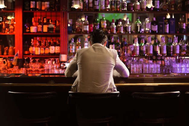 Free photo back view of a young man drinking beer