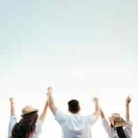 Free photo backview of friends at the beach with sky background