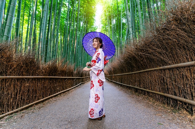 Free photo bamboo forest. asian woman wearing japanese traditional kimono at bamboo forest in kyoto, japan.