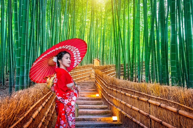 Free photo bamboo forest. asian woman wearing japanese traditional kimono at bamboo forest in kyoto, japan.