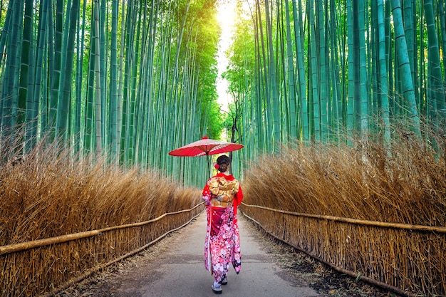 Free photo bamboo forest. asian woman wearing japanese traditional kimono at bamboo forest in kyoto, japan.