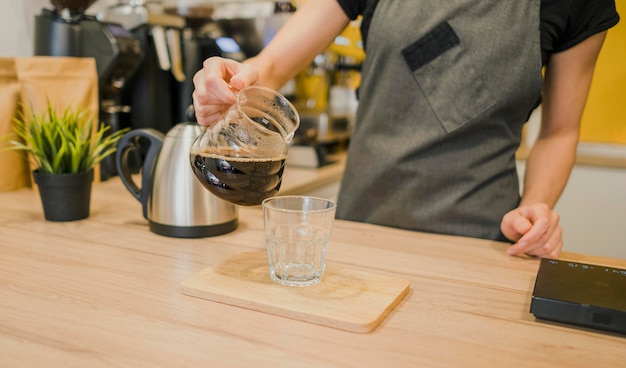 Free photo barista pouring coffee in glass