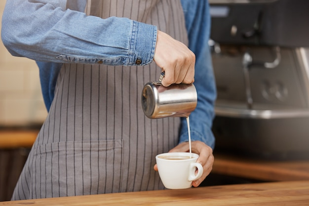 Free photo barista preparing cup of latte for customer in coffee shop.