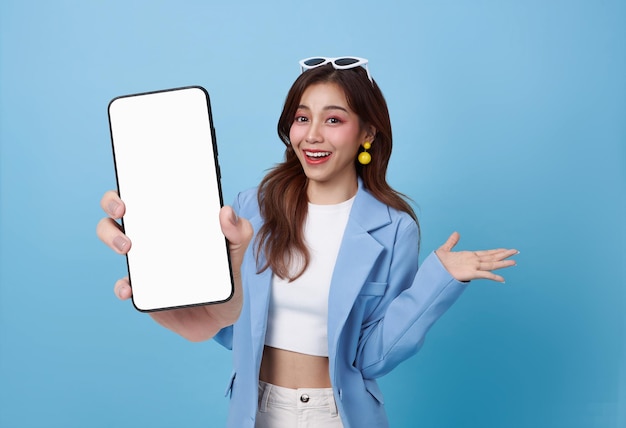 Free photo beautiful asian business woman showing smartphone mockup of blank screen isolated on blue background