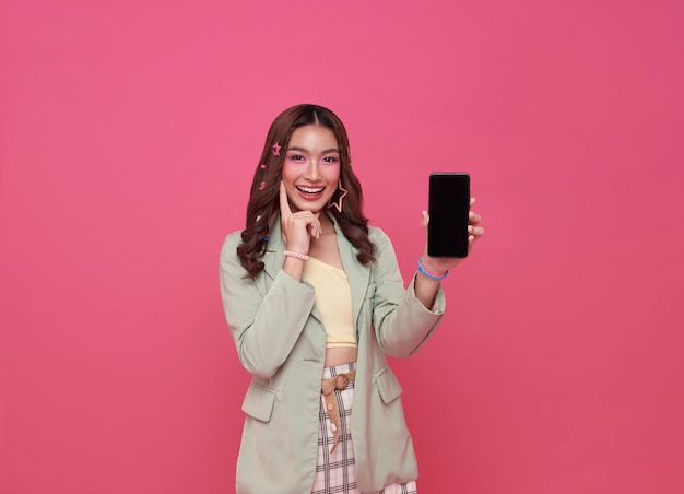 Free photo beautiful asian woman showing smartphone mockup of blank screen isolated on pink background