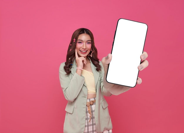 Free photo beautiful asian woman showing smartphone mockup of blank screen isolated on pink background