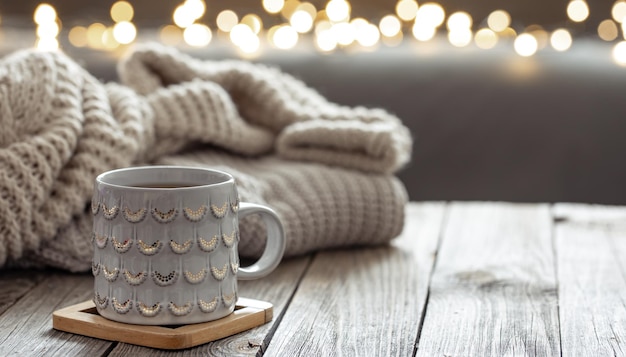 Beautiful christmas cup and knitted element on blurred background with bokeh