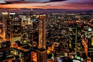 Free photo beautiful city with high skyscrapers gleaming under the colourful sky at night