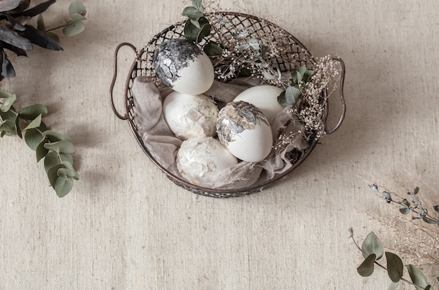 Free Photo beautiful easter eggs in a basket decorated with dried flowers. happy easter concept.