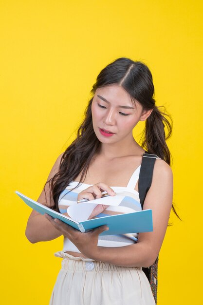 Beautiful female students hold notebooks and pens 