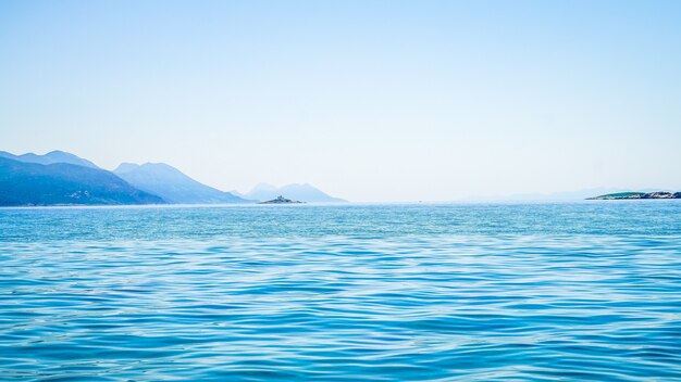 Beautiful shot of sea with a mountain in the distance and a clear sky