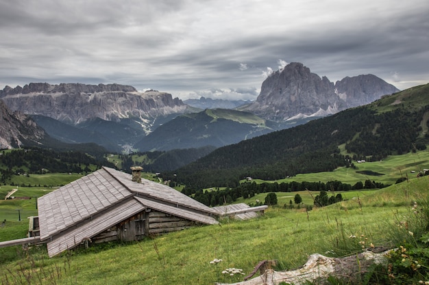 Foto gratuita bella ripresa di una casa in legno nella verde valle del parco naturale puez-odle a miscì, italia