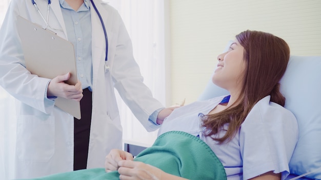 Free photo beautiful smart asian doctor and patient discussing and explaining something with clipboard