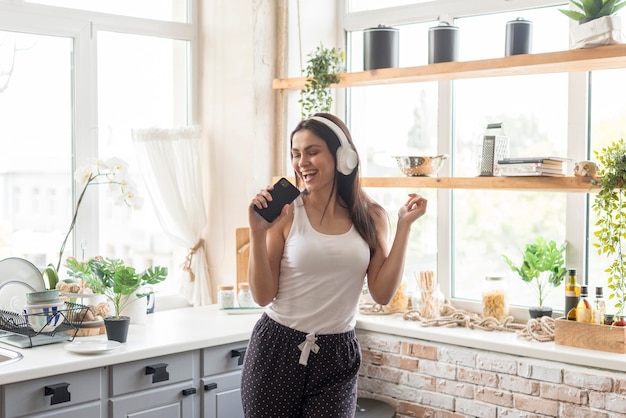 Beautiful woman singing in the kitchen