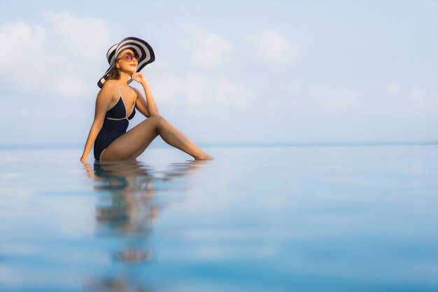  beautiful young asian woman relax around swimming pool in hotel resort