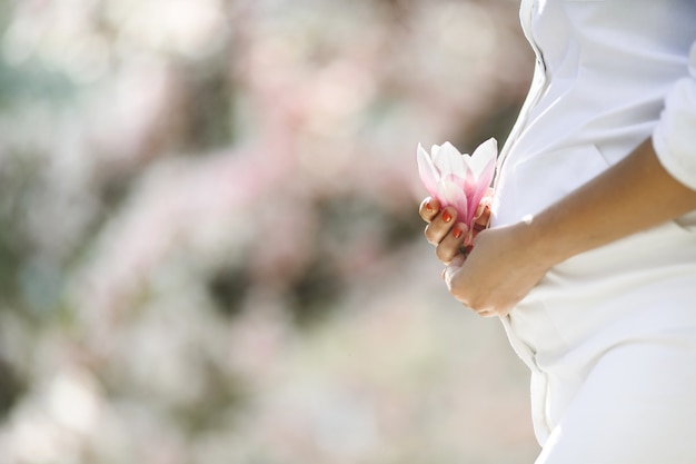 Free photo belly of a pregnant woman and a flower