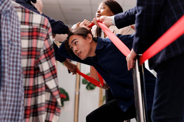 Free Photo black friday and cyber monday madness. young asian guy shopper breaking through crowd control barrier while waiting in line for sales, bargain-hunters break into clothing store