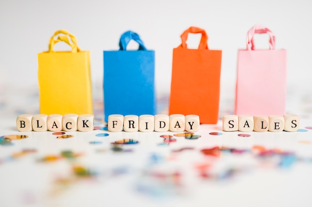 Free photo black friday sales inscription on cubes with colourful shopping bags