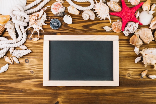 Free photo blackboard near compass and seashells