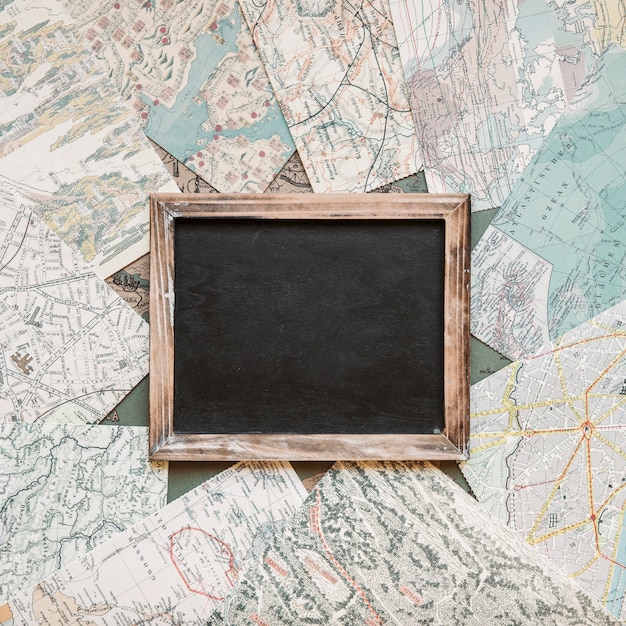 Free photo blackboard on table with maps