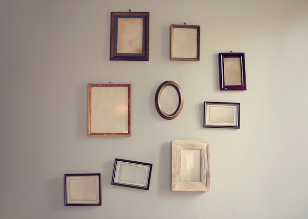 Free photo blank empty photo frames hanging on the wall