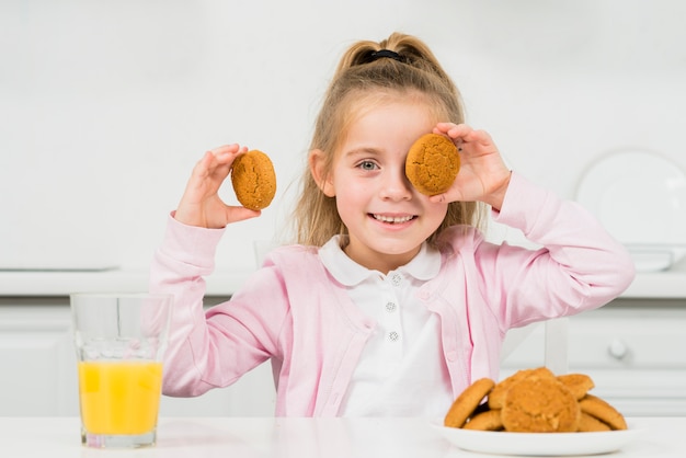 Free photo blonde girl with cookies and juice