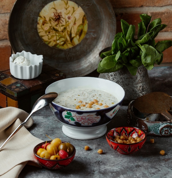 Free Photo a bowl of traditional yogurt soup with yellow beans inside, served with marinated vegetables