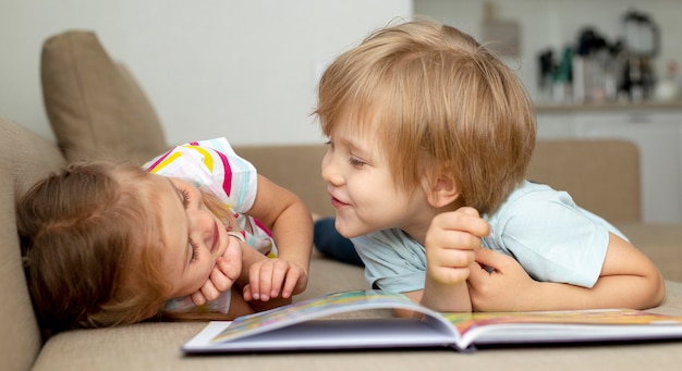 Free photo boy and girl reading at home