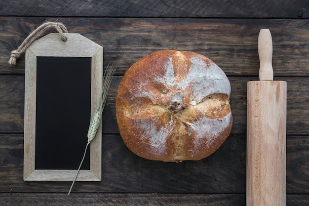 Bread between rolling pin and blackboard