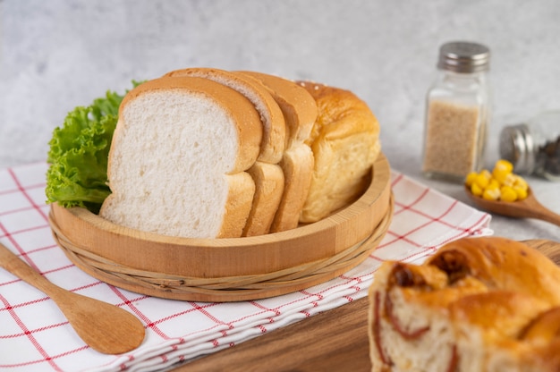 Foto gratuita pane in un vassoio di legno su un panno rosso e bianco.