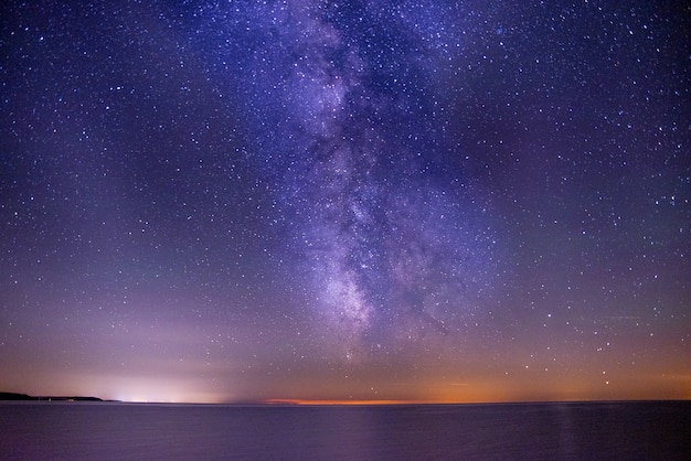 Free photo breathtaking shot of the sea under a dark and purple sky filled with stars