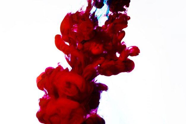 Bright red drop of ink underwater