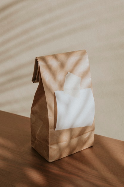 Free photo brown paper bag with a blank white notepaper