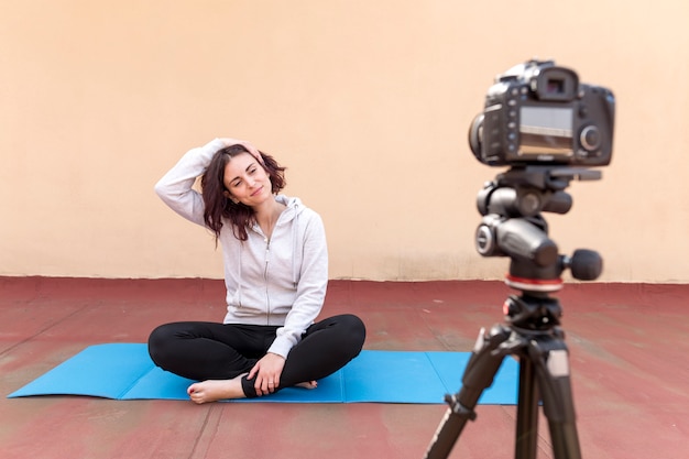 Foto gratuita blogger bruna che registra la routine di yoga