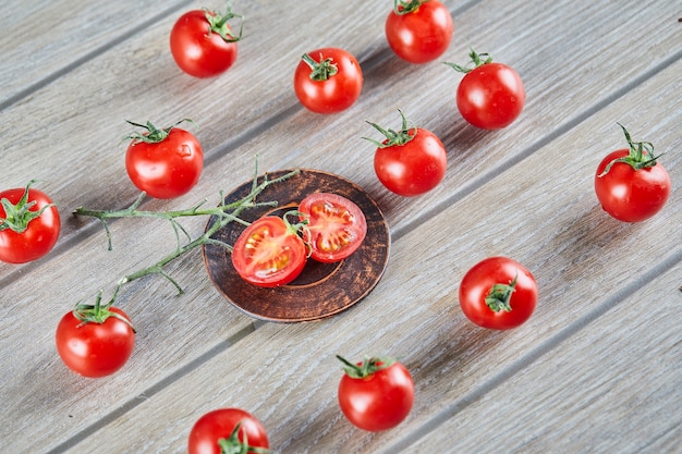 Free Photo bunch of fresh juicy tomatoes and slices of tomato on wooden table.