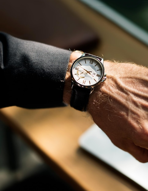 Free photo businessman looking at his watch closeup