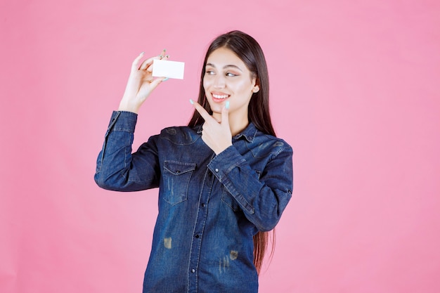 Free Photo businesswoman holding and pointing at her business card