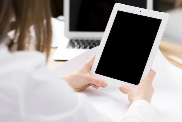 Free photo businesswoman's hand holding digital tablet in hand over the desk