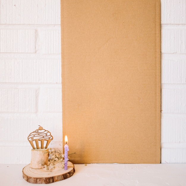 Free photo candle and wooden muffin near blank cardboard